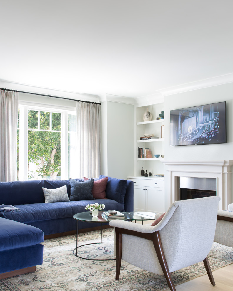 Immagine di un soggiorno classico con camino classico e TV a parete