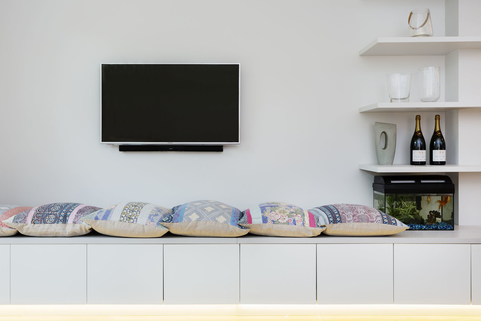 Photo of a medium sized modern living room in London with white walls and a wall mounted tv.