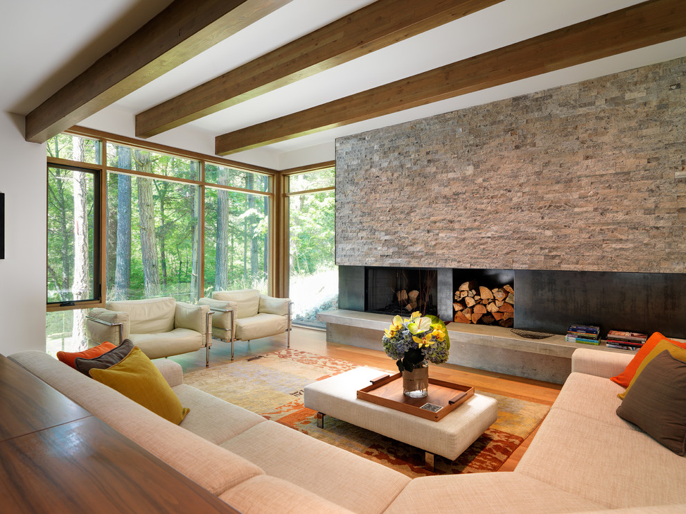 Großes, Offenes, Fernseherloses Modernes Wohnzimmer mit Kaminumrandung aus Metall, weißer Wandfarbe, braunem Holzboden, Kamin und braunem Boden in Vancouver
