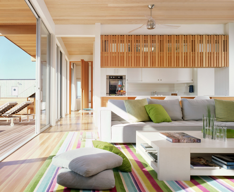Immagine di un grande soggiorno stile marinaro aperto con pareti bianche e pavimento in legno massello medio
