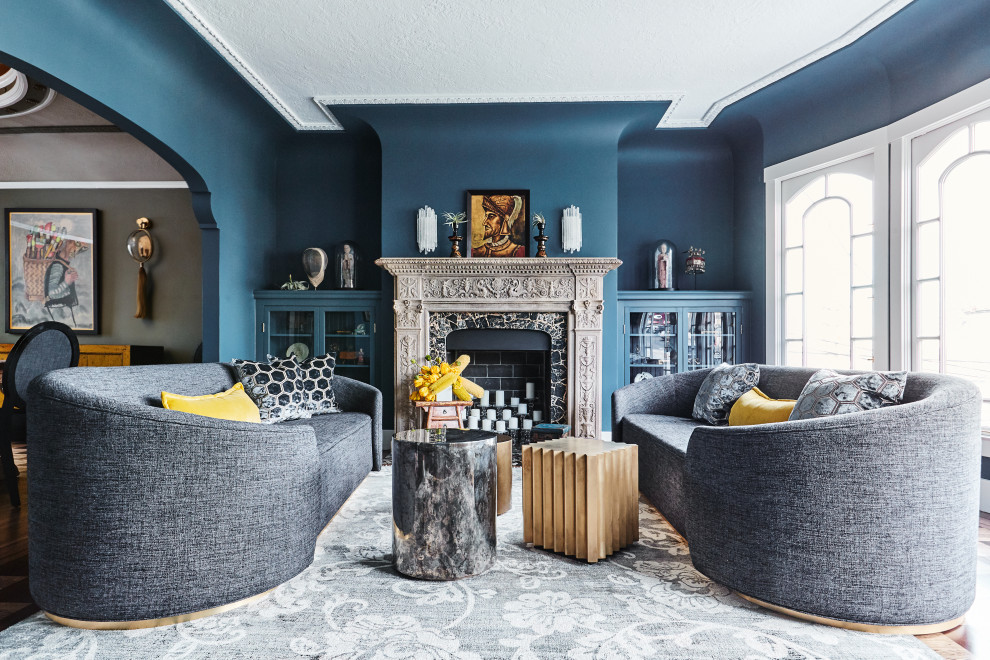 This is an example of a medium sized eclectic formal enclosed living room in San Francisco with blue walls, a standard fireplace, a stone fireplace surround and no tv.