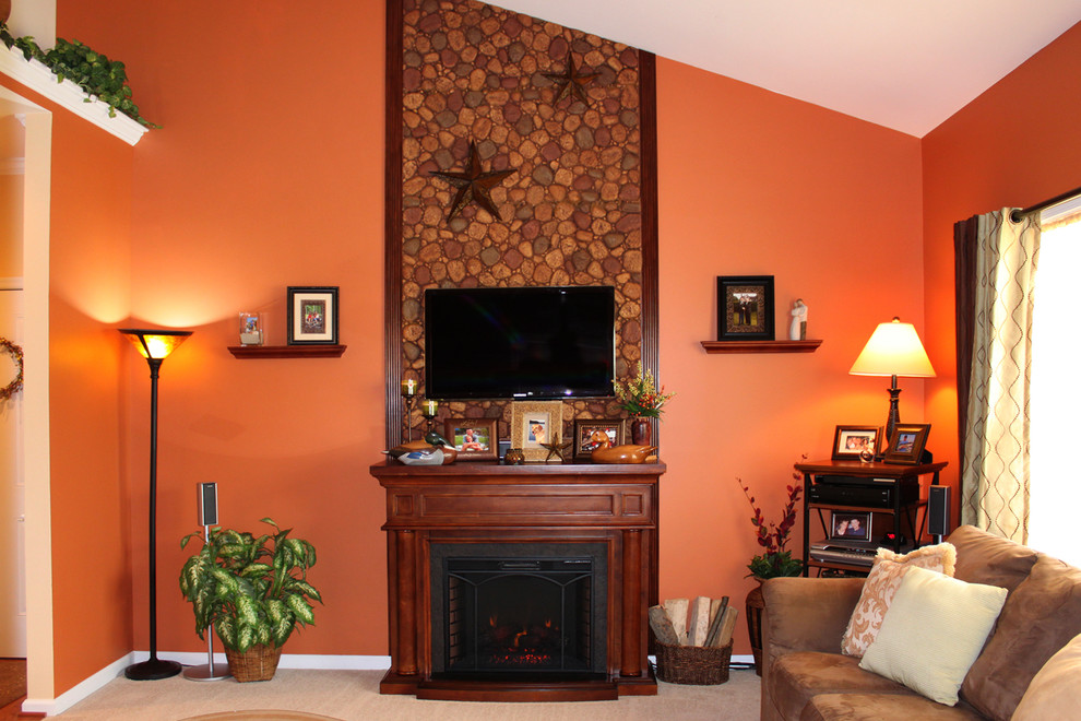 Exemple d'un salon chic fermé avec un mur orange, moquette, une cheminée standard et un téléviseur fixé au mur.