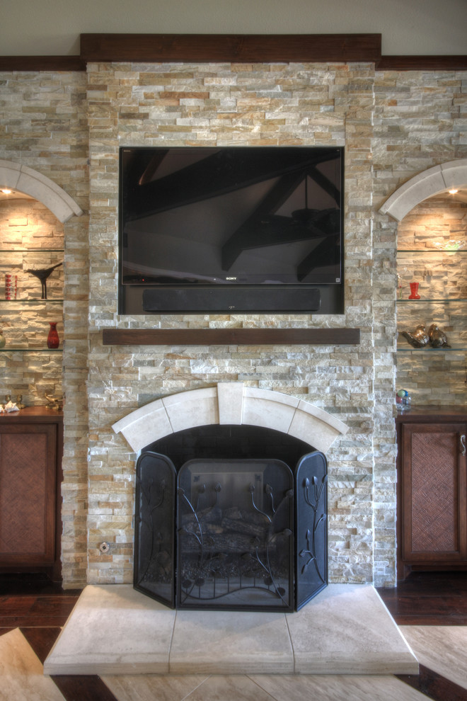 This is an example of a medium sized traditional formal open plan living room in Austin with beige walls, a standard fireplace, a stone fireplace surround and a wall mounted tv.