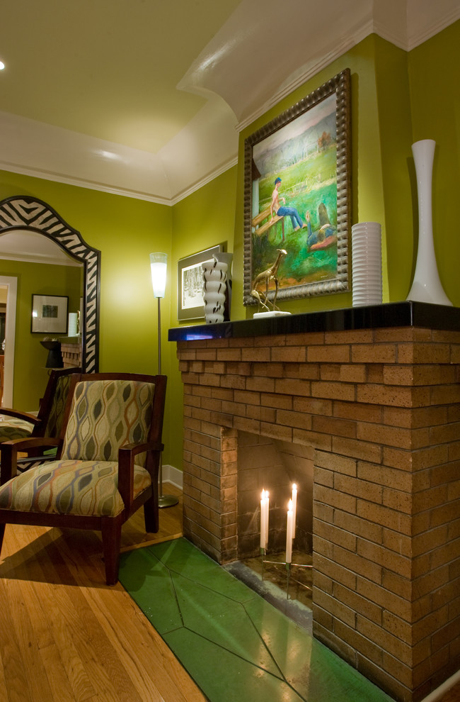 Cette photo montre un salon éclectique avec un manteau de cheminée en brique et canapé noir.