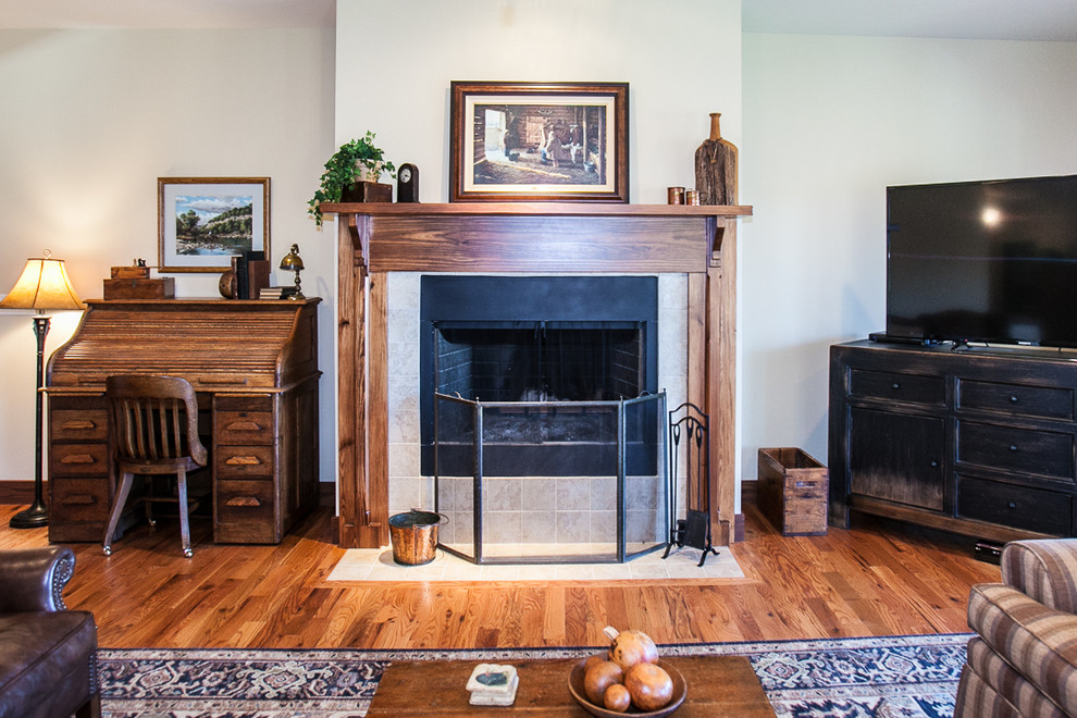 Foto di un soggiorno stile americano di medie dimensioni e aperto con pareti beige, pavimento in legno massello medio, stufa a legna, cornice del camino in legno e TV autoportante