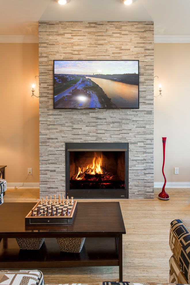 Inspiration for a contemporary open plan living room in Cincinnati with bamboo flooring, a standard fireplace, a stone fireplace surround and a wall mounted tv.
