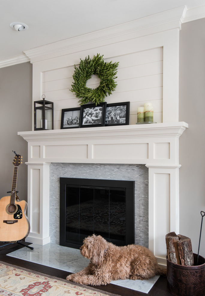 デトロイトにあるお手頃価格のトラディショナルスタイルのおしゃれなLDK (グレーの壁、濃色無垢フローリング、標準型暖炉、タイルの暖炉まわり、ライブラリー、茶色い床) の写真