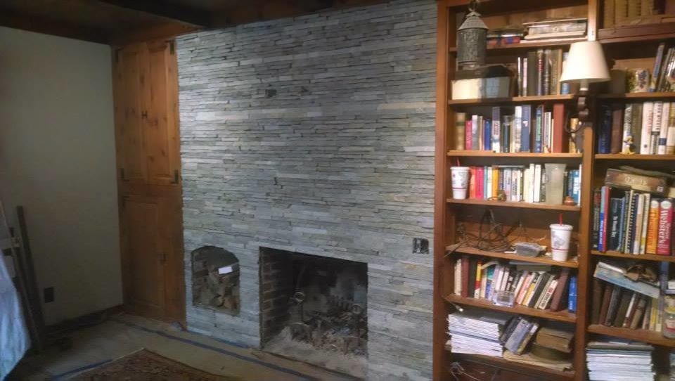 他の地域にある中くらいなラスティックスタイルのおしゃれな独立型リビング (ライブラリー、ベージュの壁、標準型暖炉、石材の暖炉まわり、テレビなし) の写真