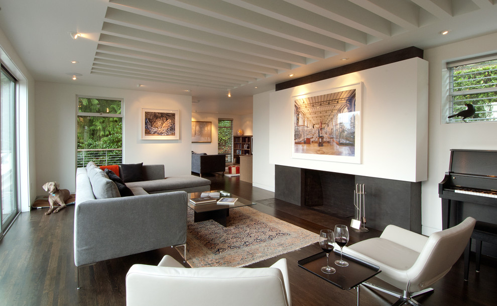 Ejemplo de salón abierto actual con paredes blancas, suelo de madera oscura, todas las chimeneas y suelo marrón