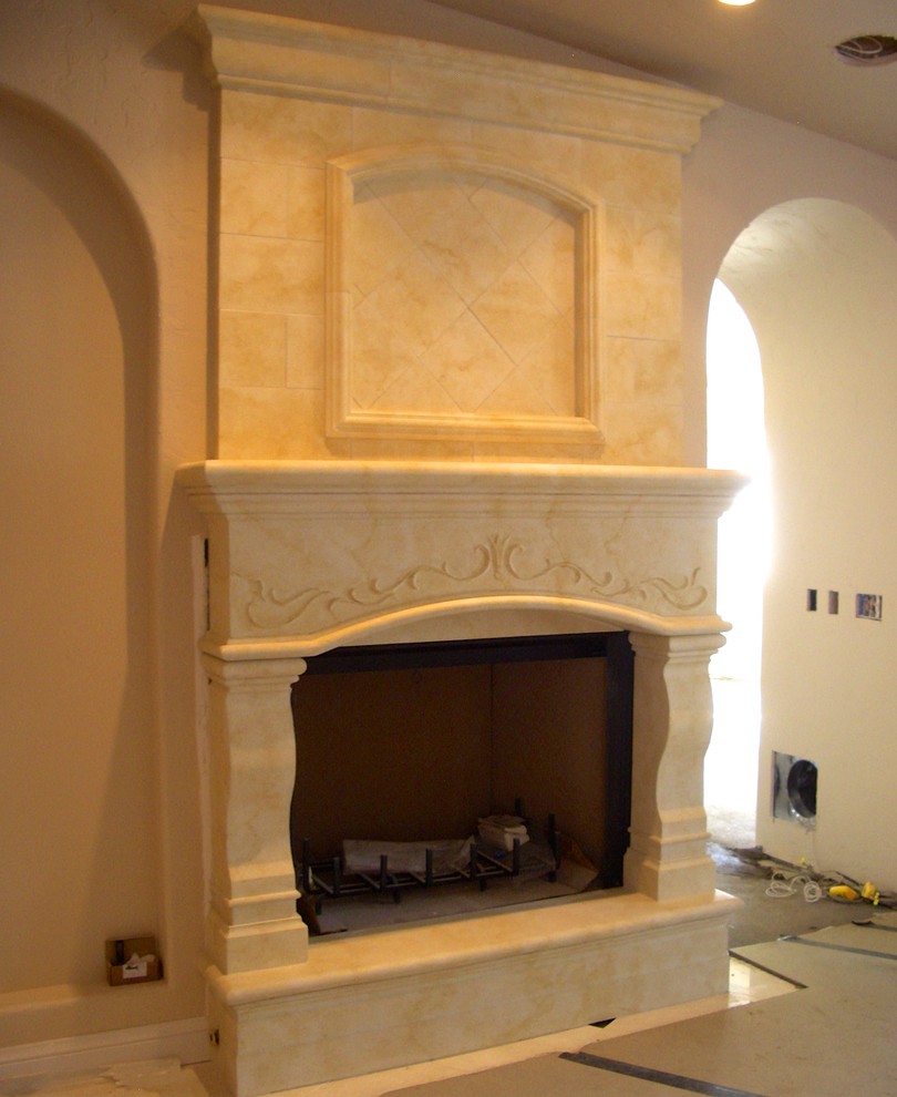 Imagen de salón mediterráneo con marco de chimenea de piedra
