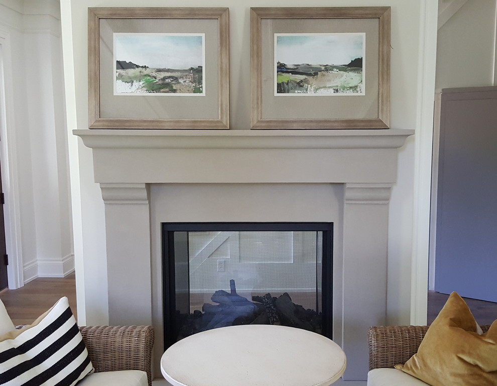 他の地域にある低価格のトラディショナルスタイルのおしゃれなリビング (白い壁、無垢フローリング、標準型暖炉、漆喰の暖炉まわり) の写真