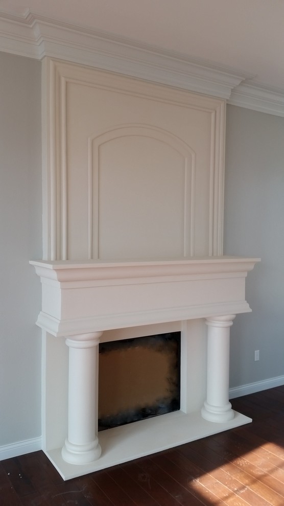 Photo of a traditional living room in Other with white walls, medium hardwood flooring, a standard fireplace and a plastered fireplace surround.