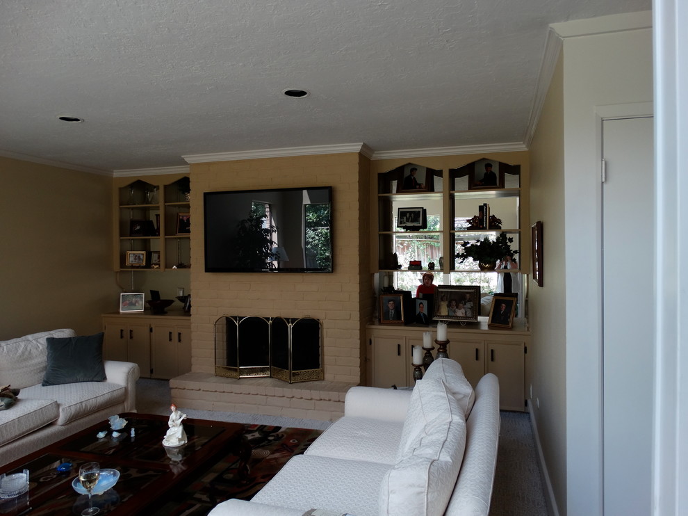 Foto på ett mellanstort vintage separat vardagsrum, med beige väggar, travertin golv, en standard öppen spis, en spiselkrans i sten och en väggmonterad TV