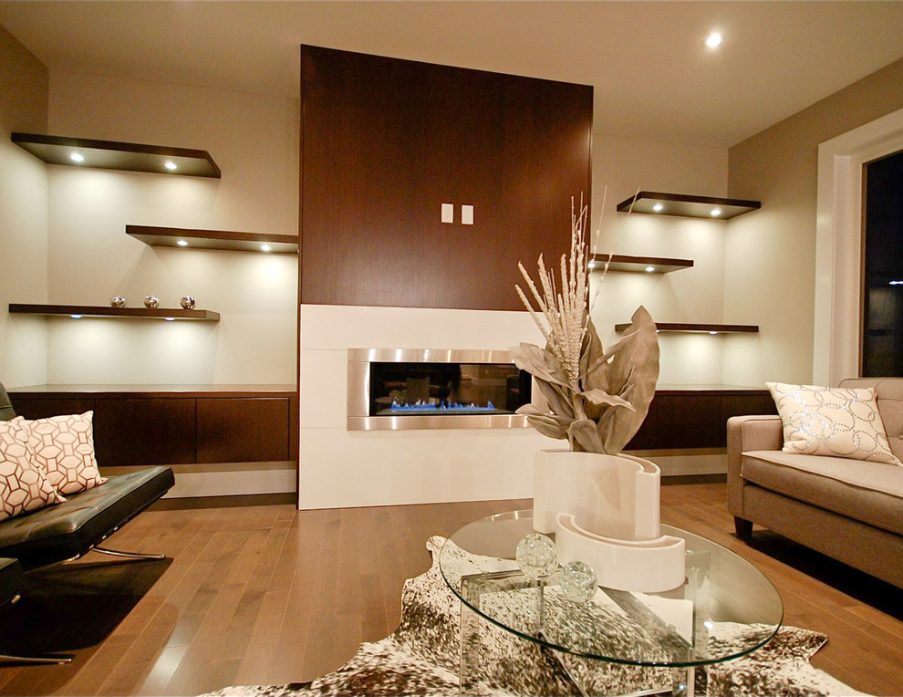 Exempel på ett stort modernt separat vardagsrum, med ett finrum, beige väggar, mellanmörkt trägolv, en bred öppen spis, en väggmonterad TV, en spiselkrans i metall och brunt golv