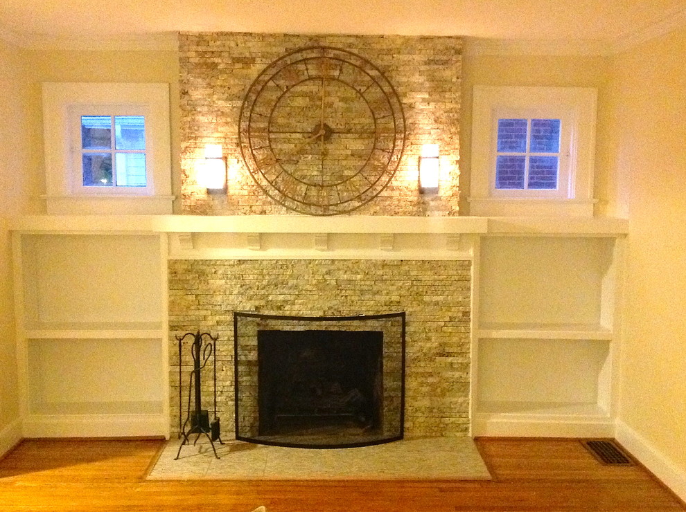 Foto de biblioteca en casa clásica de tamaño medio con paredes blancas, suelo de madera clara, todas las chimeneas y marco de chimenea de piedra