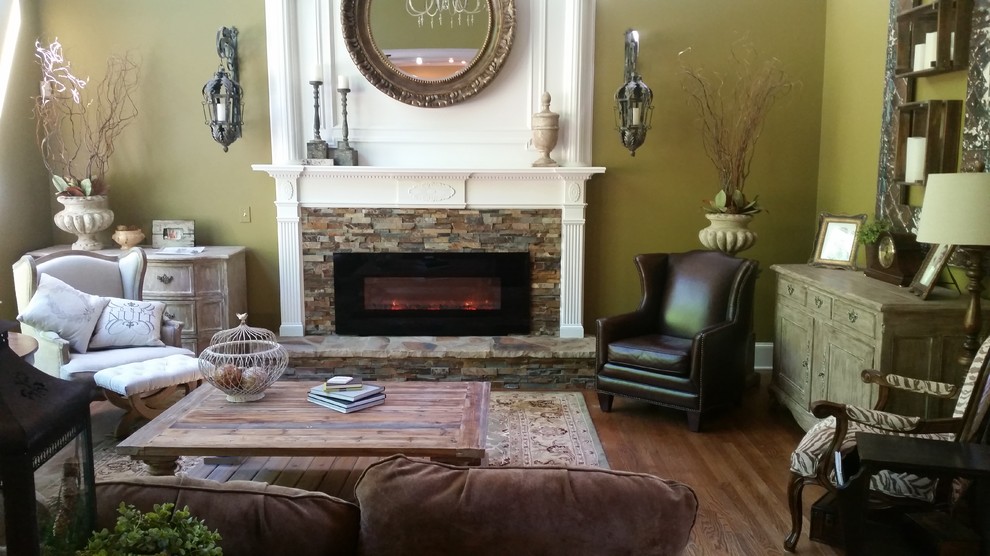 Classic living room in Atlanta with green walls, light hardwood flooring, a ribbon fireplace and a stone fireplace surround.