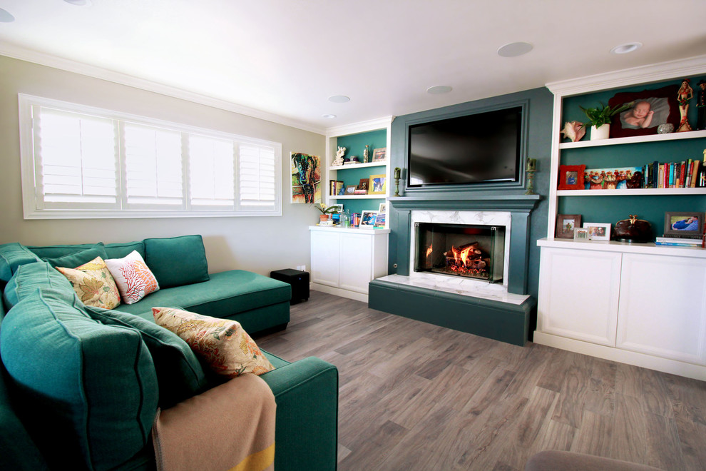 Mittelgroßes, Offenes Klassisches Wohnzimmer mit blauer Wandfarbe, Porzellan-Bodenfliesen, Kamin, Kaminumrandung aus Stein und TV-Wand in San Diego