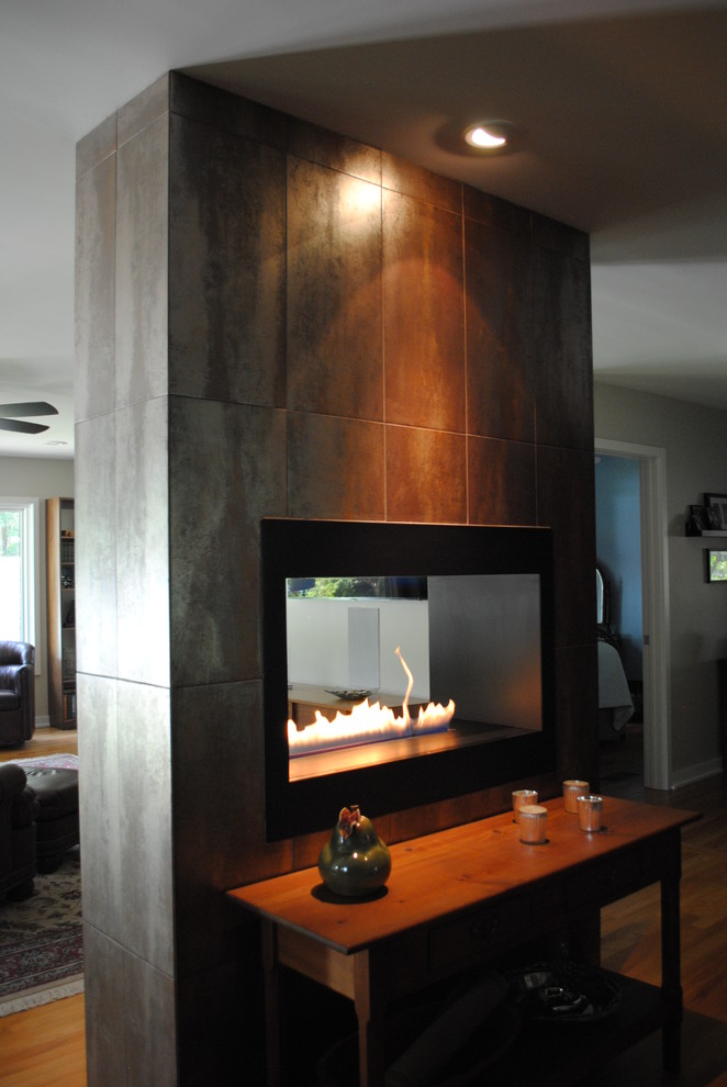 Aménagement d'un salon moderne avec une cheminée ribbon et un manteau de cheminée en carrelage.
