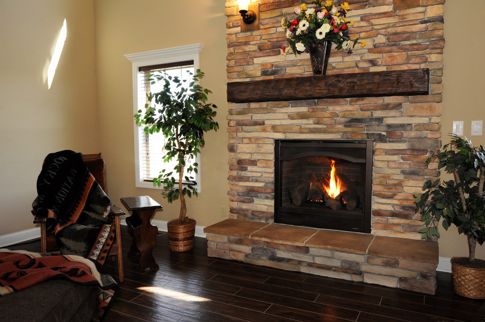 Example of a mid-sized classic formal and enclosed dark wood floor and brown floor living room design in Cleveland with beige walls, a standard fireplace, a stone fireplace and no tv