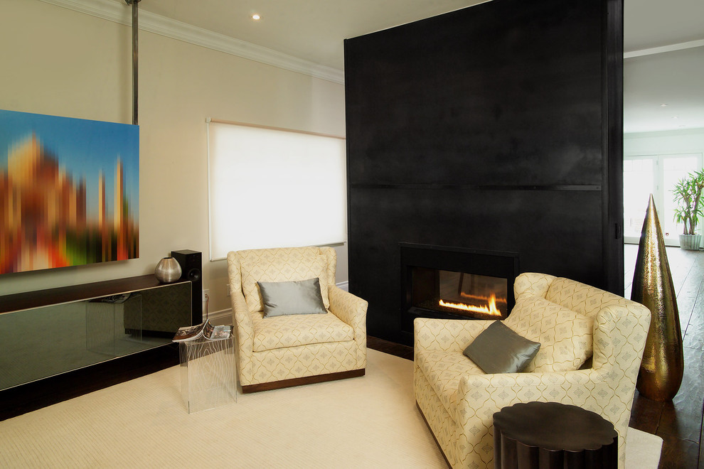 Foto di un soggiorno minimal con pareti beige e camino bifacciale
