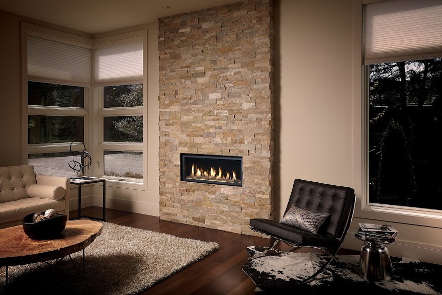 Inspiration pour un salon design de taille moyenne et ouvert avec un mur beige, un sol en bois brun, une cheminée standard et un manteau de cheminée en pierre.