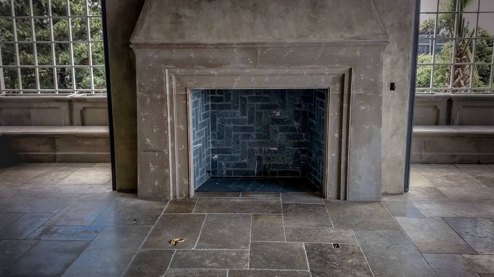 Esempio di un grande soggiorno classico con pavimento in pietra calcarea, cornice del camino in pietra, camino classico e sala formale