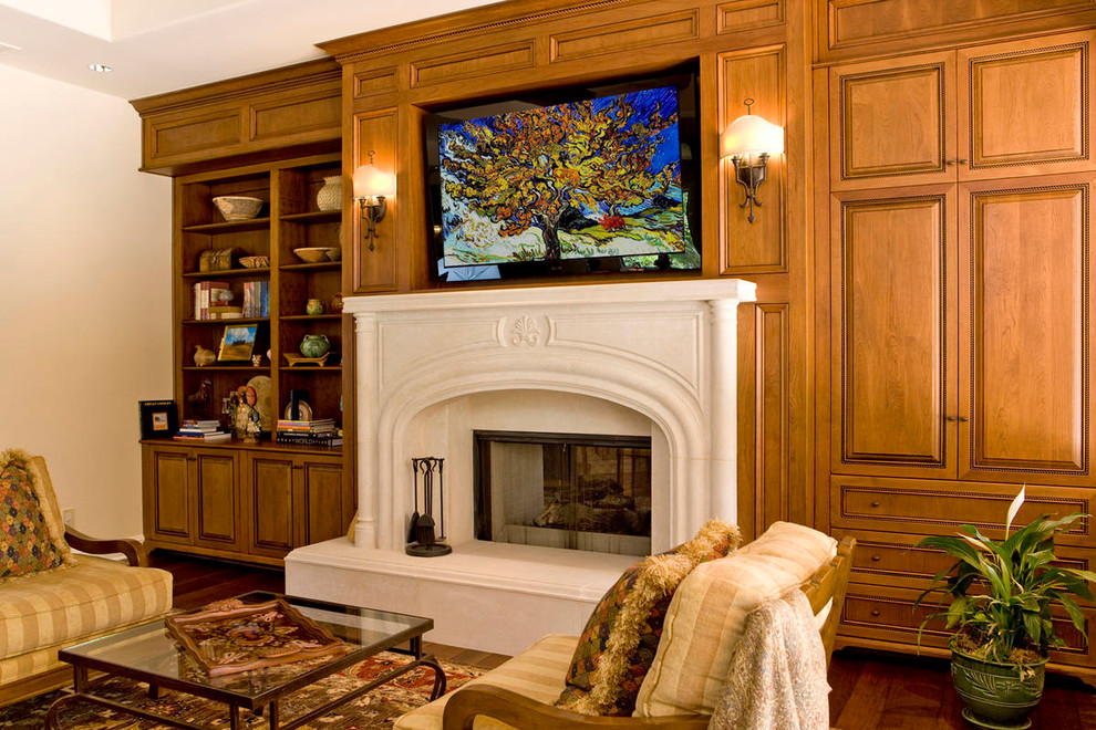 Klassisk inredning av ett mellanstort separat vardagsrum, med ett bibliotek, beige väggar, mörkt trägolv, en standard öppen spis, en spiselkrans i sten och en väggmonterad TV
