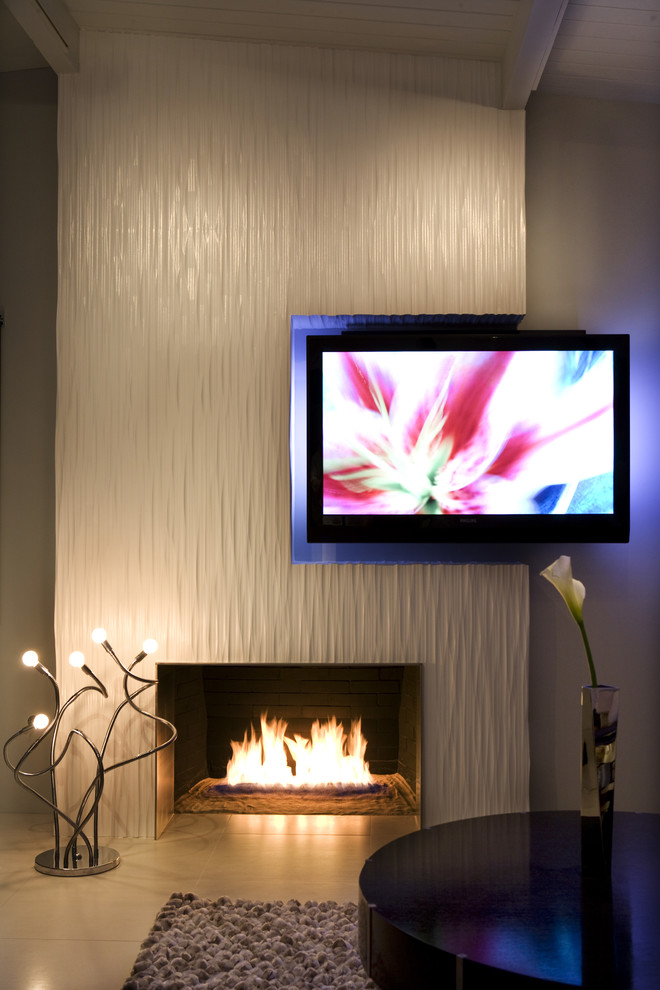 ロサンゼルスにある高級な広いコンテンポラリースタイルのおしゃれなLDK (標準型暖炉、白い壁、磁器タイルの床、金属の暖炉まわり、埋込式メディアウォール、白い床) の写真