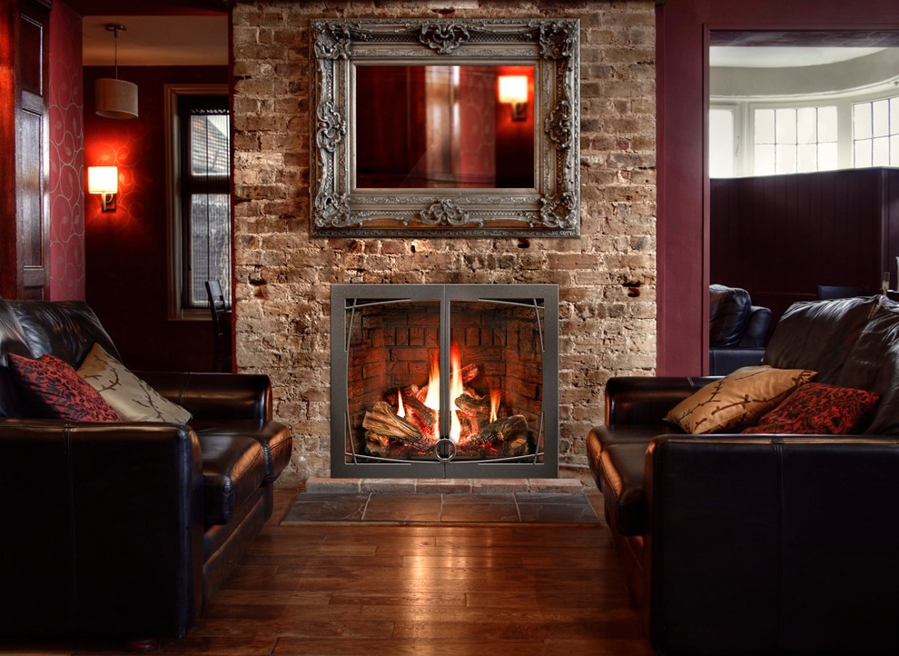 Cette image montre un salon vintage de taille moyenne et ouvert avec un mur rouge, un sol en bois brun, une cheminée standard et un manteau de cheminée en brique.