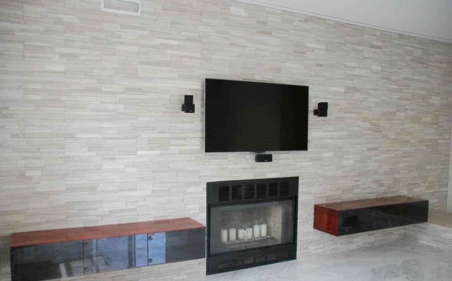 Diseño de salón abierto minimalista grande con paredes blancas, suelo de cemento, todas las chimeneas, marco de chimenea de piedra y pared multimedia