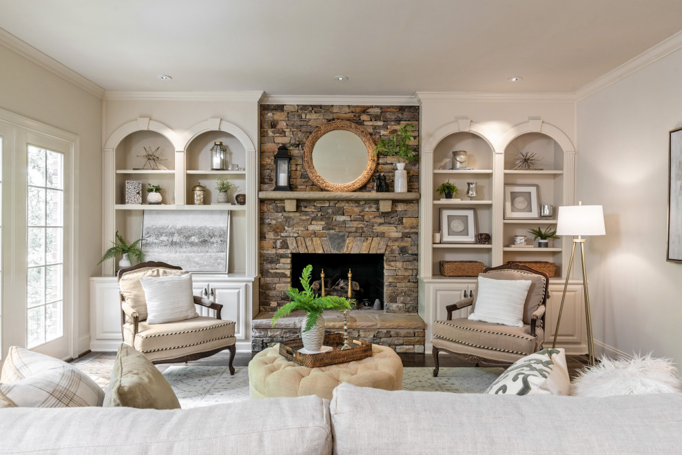 Large traditional formal living room in Charlotte with beige walls, medium hardwood flooring, a standard fireplace, a stone fireplace surround and brown floors.