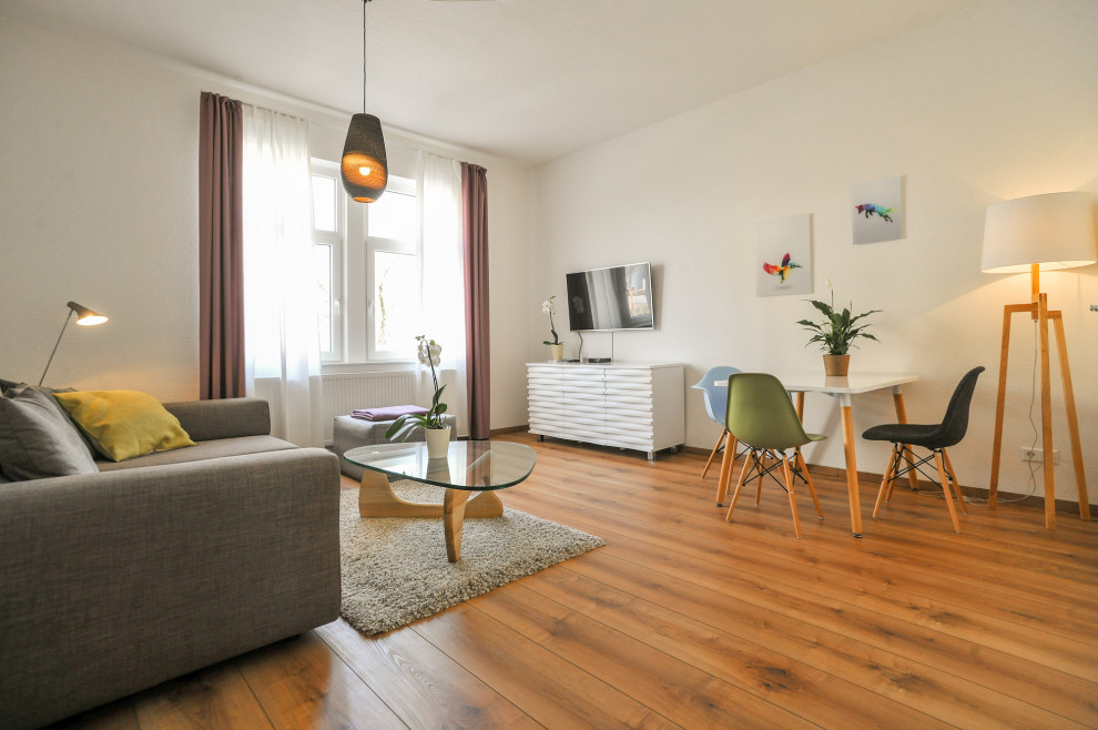 Mittelgroßes Skandinavisches Wohnzimmer mit weißer Wandfarbe, Laminat und TV-Wand in Stuttgart