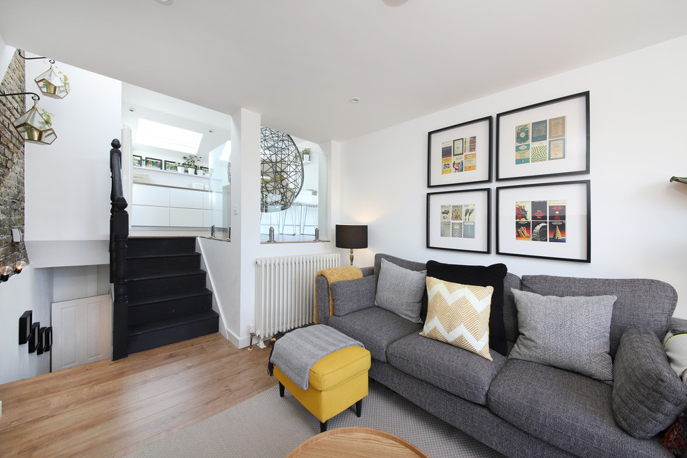 This is an example of a scandi living room in London with white walls and medium hardwood flooring.