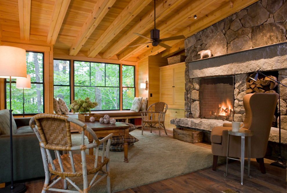 Mittelgroßes, Offenes Rustikales Wohnzimmer mit braunem Holzboden, Kamin, Kaminumrandung aus Stein und verstecktem TV in Portland Maine