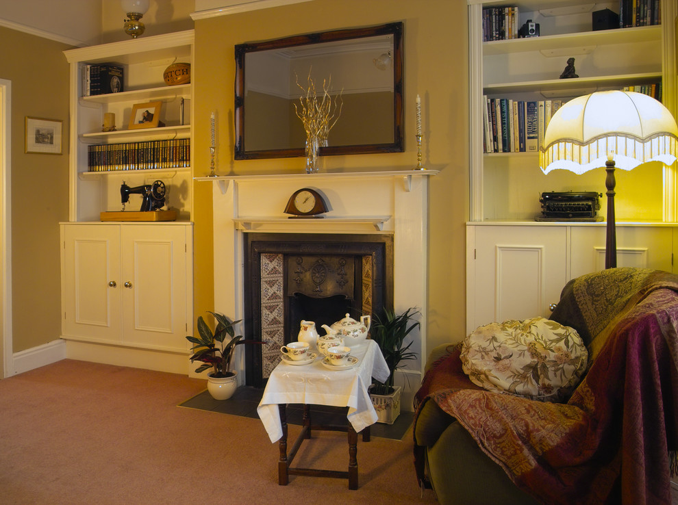 Mittelgroßes, Abgetrenntes Klassisches Wohnzimmer mit brauner Wandfarbe, Teppichboden, Kamin und Kaminumrandung aus Holz in Sonstige