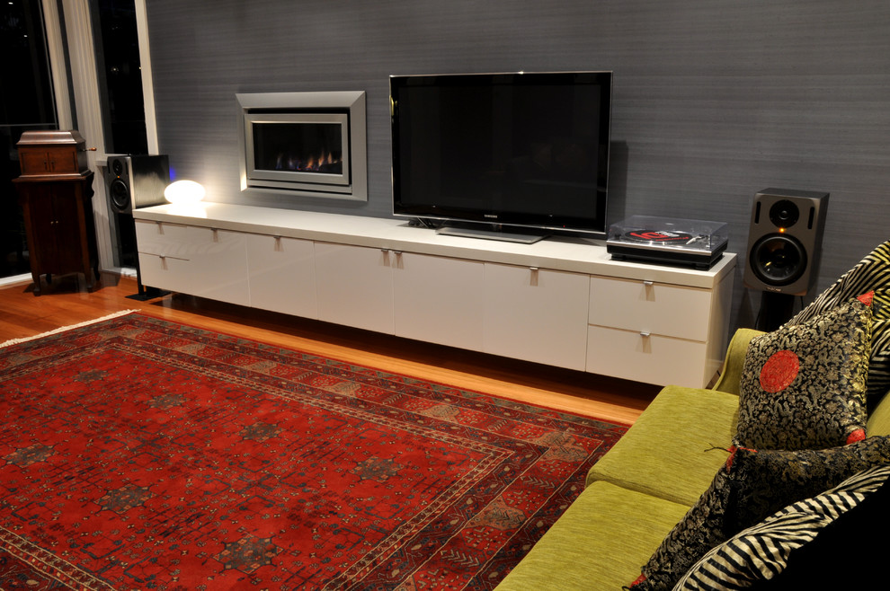 Mittelgroßes, Offenes Modernes Wohnzimmer mit weißer Wandfarbe, hellem Holzboden, freistehendem TV, Kamin und verputzter Kaminumrandung in Geelong