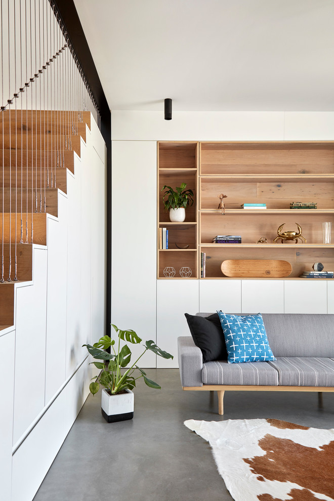 Kleines, Offenes Modernes Wohnzimmer mit weißer Wandfarbe, Betonboden und grauem Boden in Melbourne