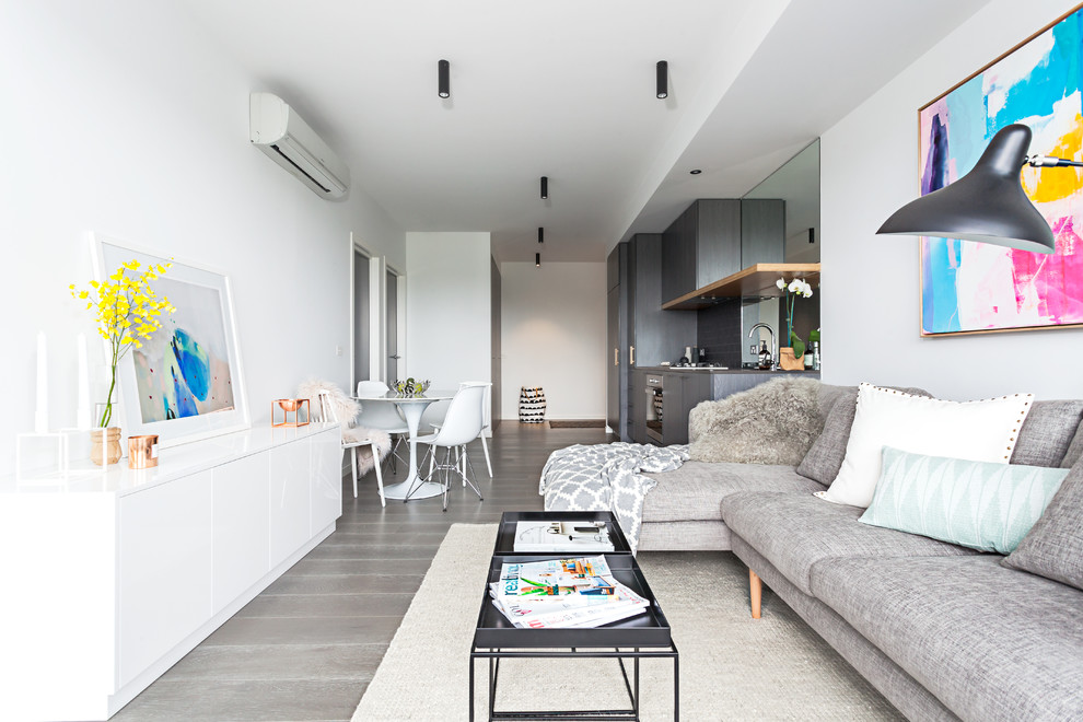 Kleines, Fernseherloses Modernes Wohnzimmer ohne Kamin mit weißer Wandfarbe und braunem Holzboden in Melbourne