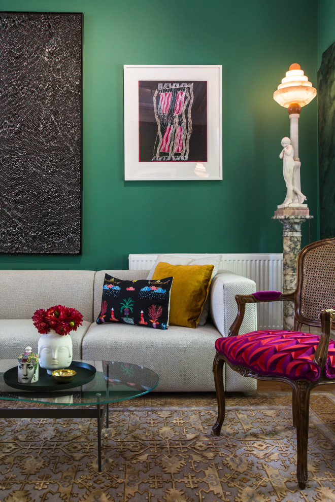 Esempio di un soggiorno eclettico di medie dimensioni e aperto con pareti verdi e parquet chiaro