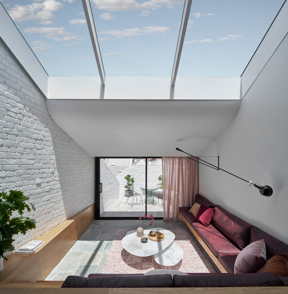 Bild på ett mellanstort funkis allrum med öppen planlösning, med vita väggar, kalkstensgolv och grått golv