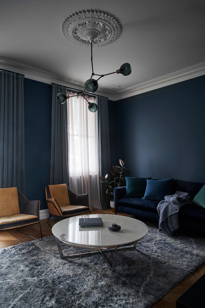 На фото: парадная, изолированная гостиная комната среднего размера в классическом стиле с синими стенами, паркетным полом среднего тона, стандартным камином, фасадом камина из камня и коричневым полом без телевизора с