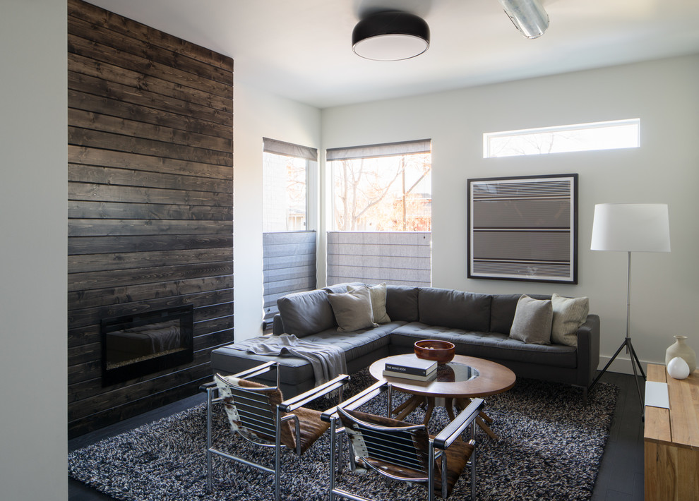 Mittelgroßes, Offenes, Repräsentatives, Fernseherloses Modernes Wohnzimmer mit weißer Wandfarbe, dunklem Holzboden, Kaminumrandung aus Holz und Gaskamin in Denver
