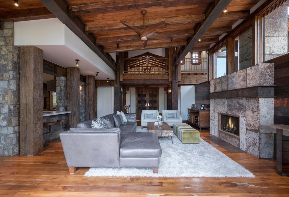 Large rustic open plan living room in Phoenix with medium hardwood flooring, a ribbon fireplace, white walls and a metal fireplace surround.