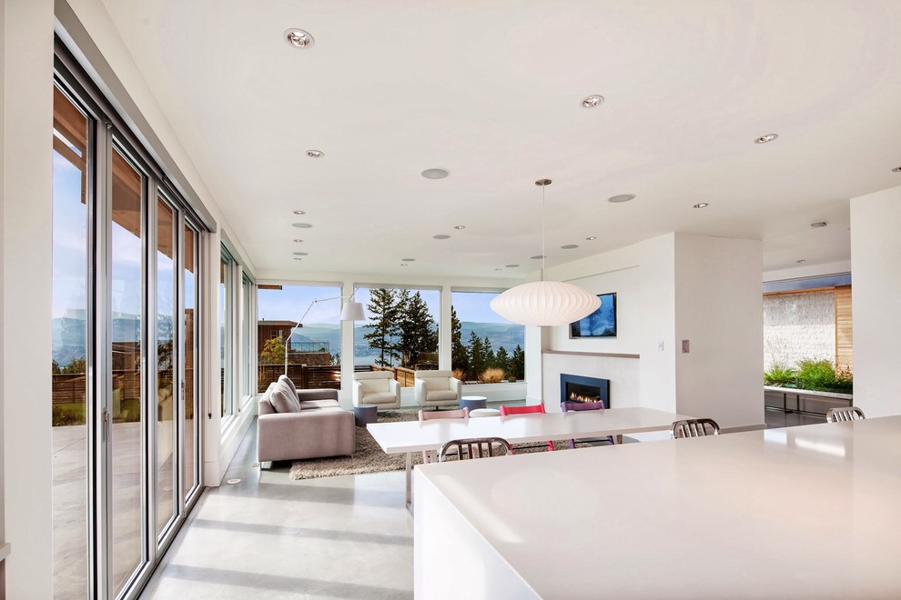 Large contemporary open plan living room in Vancouver with white walls, concrete flooring, a standard fireplace, a stone fireplace surround and a wall mounted tv.