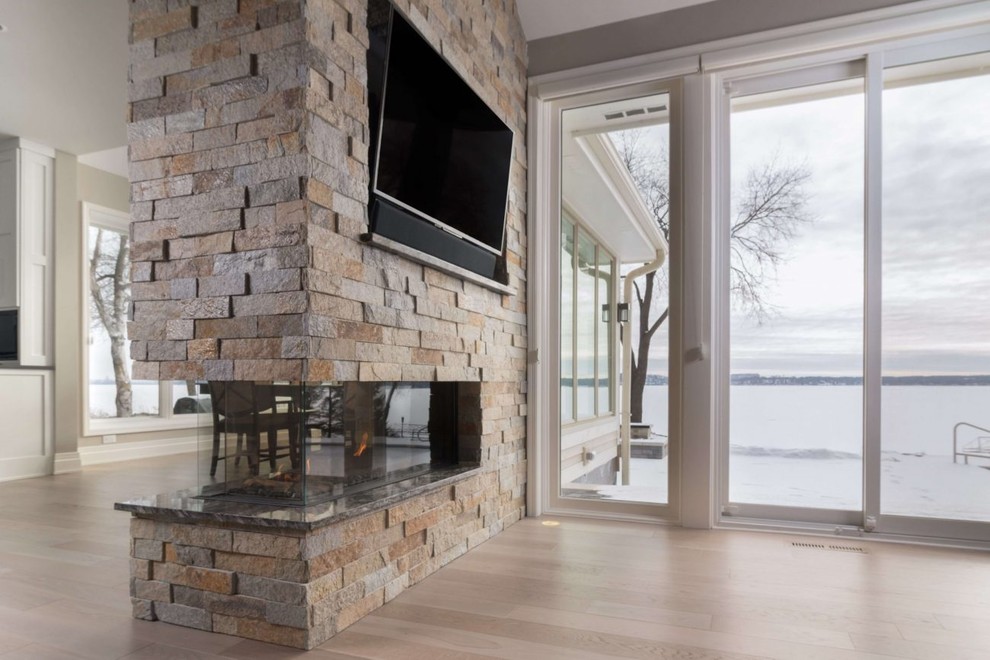 Ejemplo de salón minimalista grande con televisor colgado en la pared y marco de chimenea de piedra
