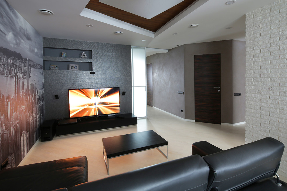 Стильный дизайн: гостиная комната в современном стиле с серыми стенами, светлым паркетным полом и телевизором на стене - последний тренд
