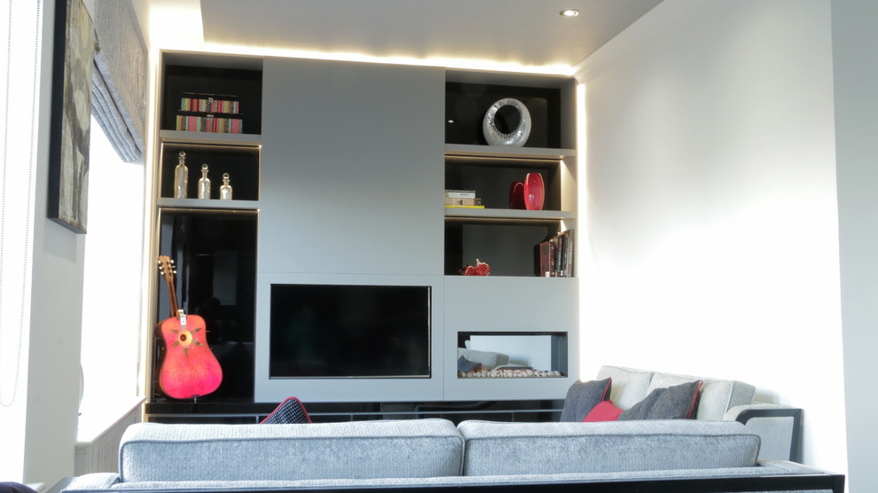 Cette photo montre un petit salon moderne ouvert avec un mur blanc, cheminée suspendue et un téléviseur encastré.