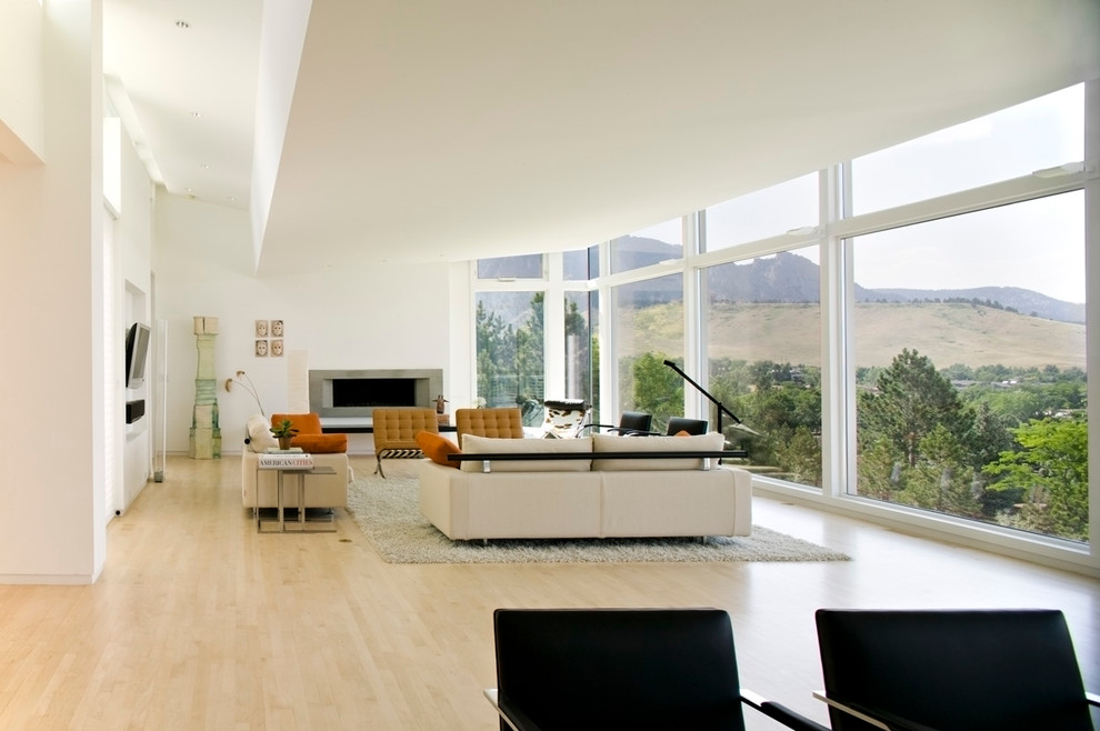 Exempel på ett stort minimalistiskt allrum med öppen planlösning, med ett finrum, vita väggar, ljust trägolv, en bred öppen spis, en spiselkrans i betong och en väggmonterad TV