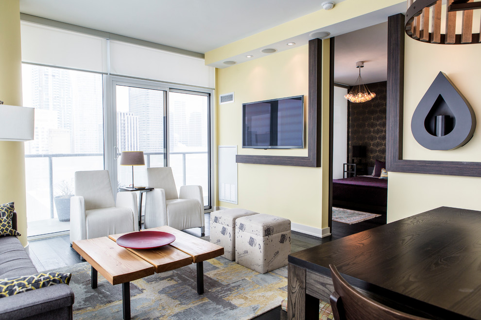 Mittelgroßes, Offenes Asiatisches Wohnzimmer mit gelber Wandfarbe, dunklem Holzboden und TV-Wand in Toronto