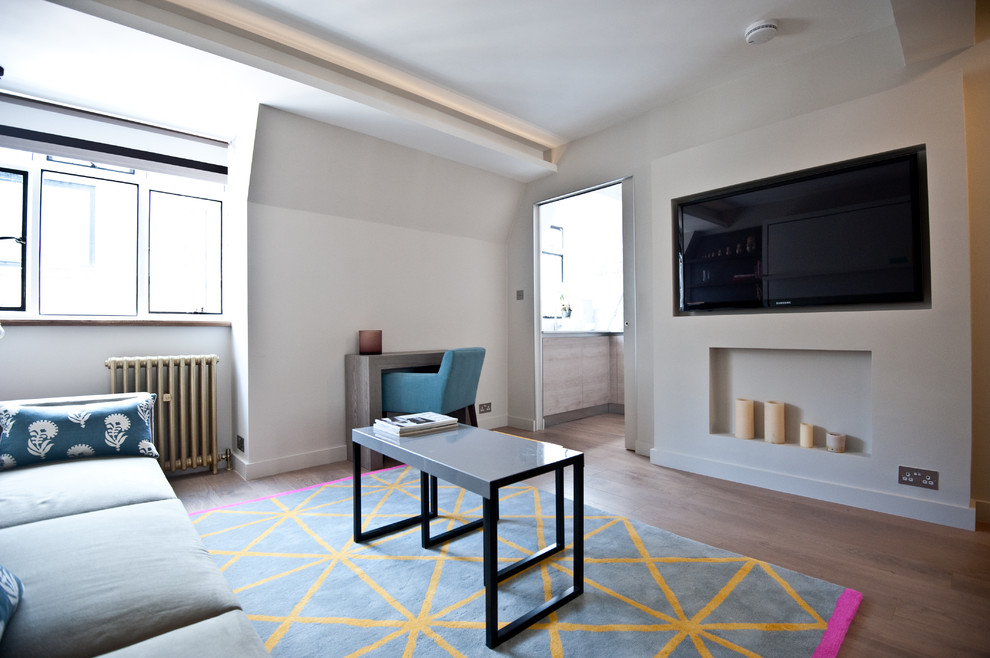 Стильный дизайн: маленькая изолированная гостиная комната в стиле модернизм с белыми стенами, темным паркетным полом и телевизором на стене для на участке и в саду - последний тренд